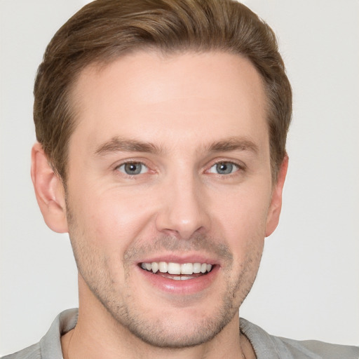 Joyful white young-adult male with short  brown hair and grey eyes