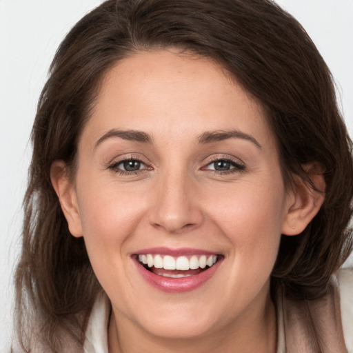 Joyful white young-adult female with long  brown hair and grey eyes