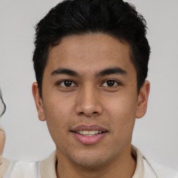 Joyful latino young-adult male with short  brown hair and brown eyes