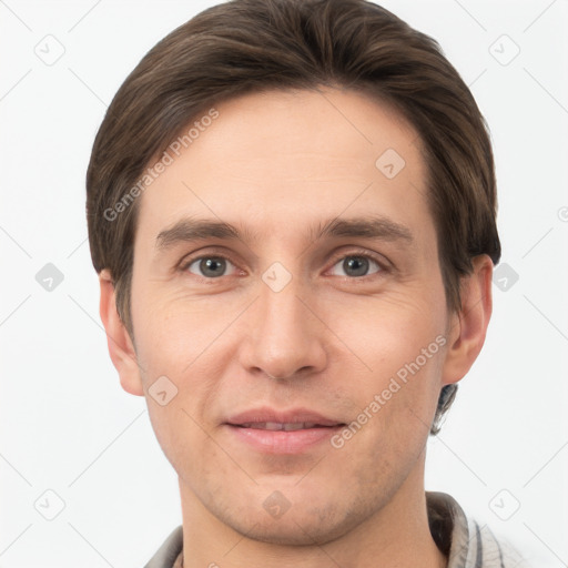 Joyful white young-adult male with short  brown hair and grey eyes