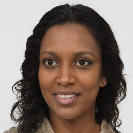 Joyful black young-adult female with long  brown hair and brown eyes