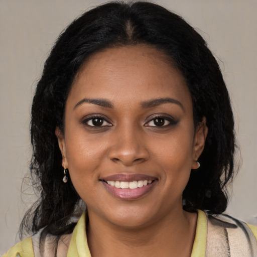 Joyful black young-adult female with long  black hair and brown eyes