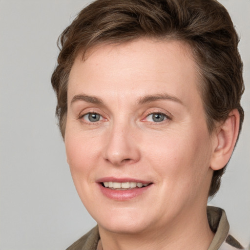 Joyful white adult female with medium  brown hair and grey eyes