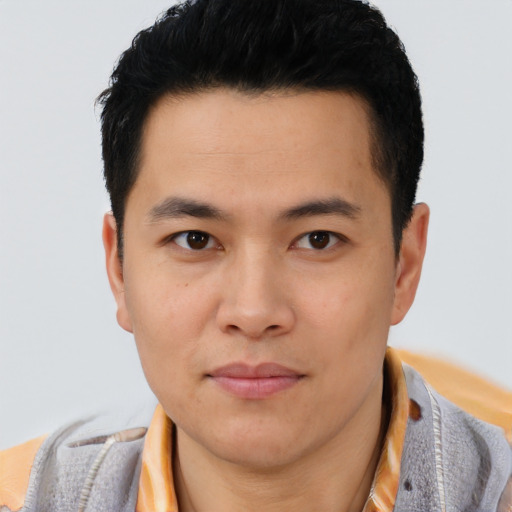 Joyful asian young-adult male with short  brown hair and brown eyes