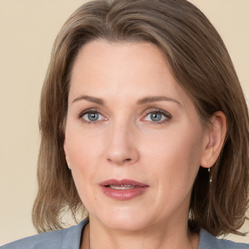 Joyful white adult female with medium  brown hair and grey eyes