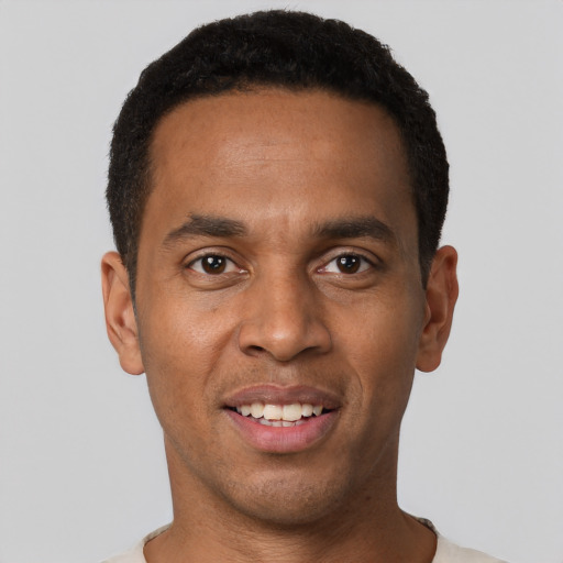 Joyful black young-adult male with short  black hair and brown eyes