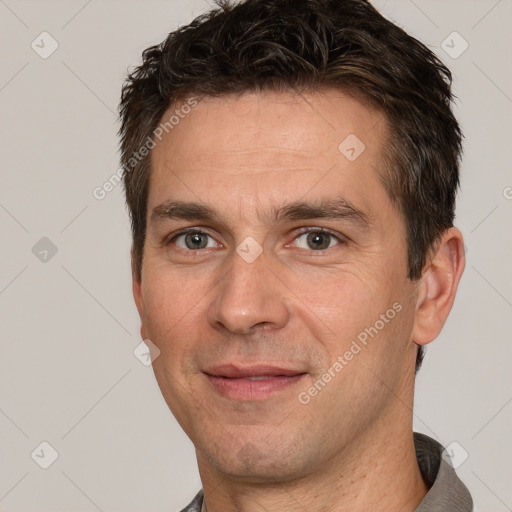 Joyful white adult male with short  brown hair and brown eyes