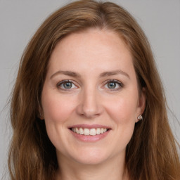 Joyful white young-adult female with long  brown hair and grey eyes