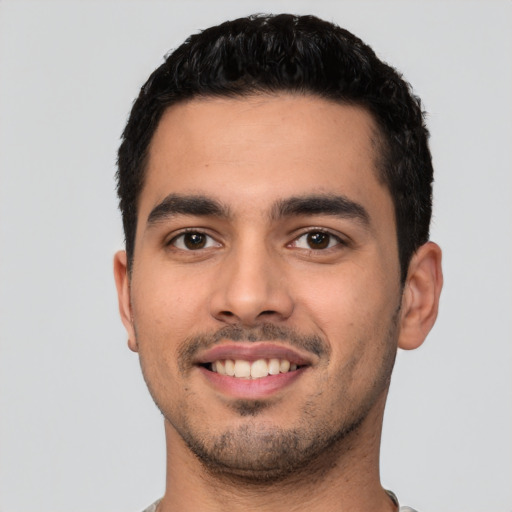 Joyful latino young-adult male with short  black hair and brown eyes