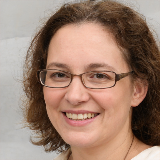 Joyful white adult female with medium  brown hair and blue eyes