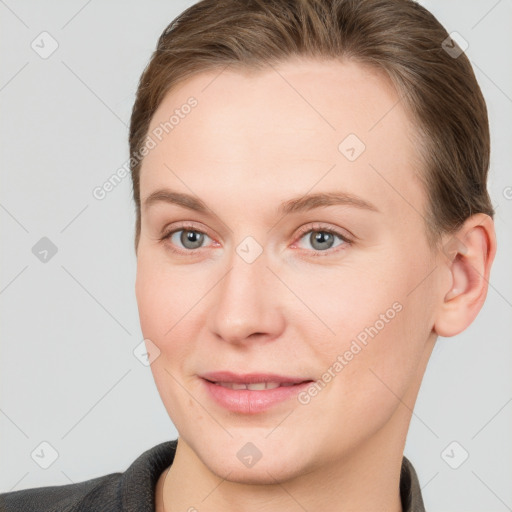 Joyful white young-adult female with short  brown hair and grey eyes