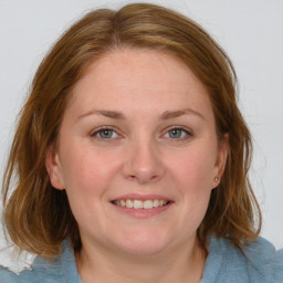 Joyful white young-adult female with medium  brown hair and blue eyes