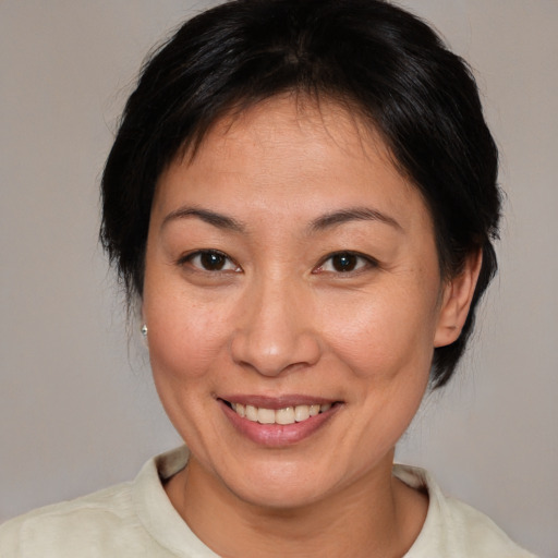 Joyful asian adult female with medium  brown hair and brown eyes