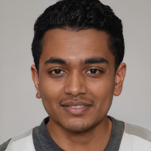 Joyful black young-adult male with short  black hair and brown eyes