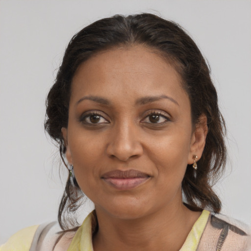 Joyful black adult female with medium  brown hair and brown eyes