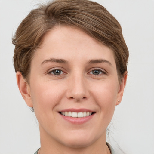 Joyful white young-adult female with short  brown hair and grey eyes