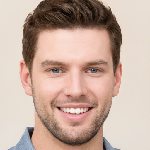 Joyful white young-adult male with short  brown hair and grey eyes