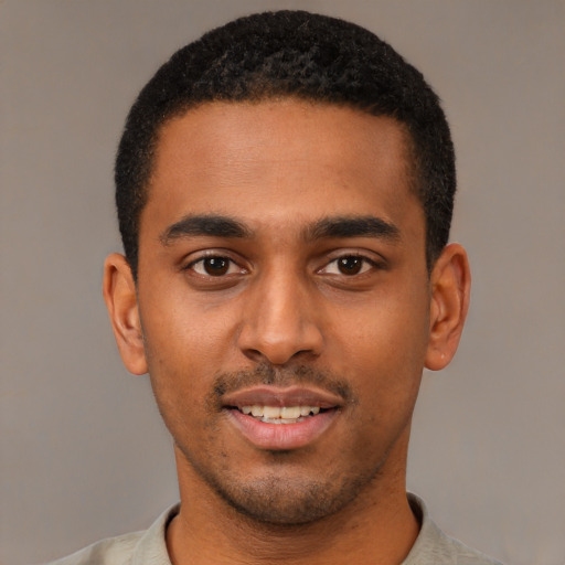 Joyful black young-adult male with short  black hair and brown eyes