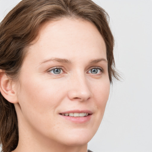 Joyful white young-adult female with medium  brown hair and blue eyes