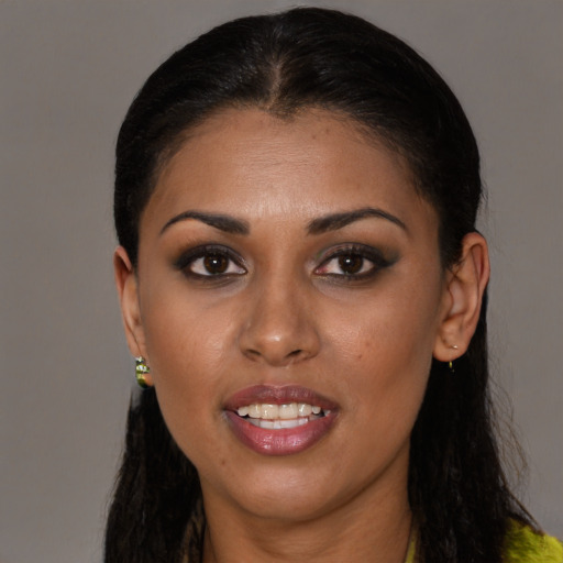 Joyful black young-adult female with long  brown hair and brown eyes