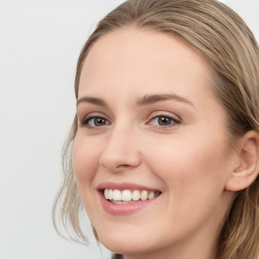 Joyful white young-adult female with long  brown hair and blue eyes