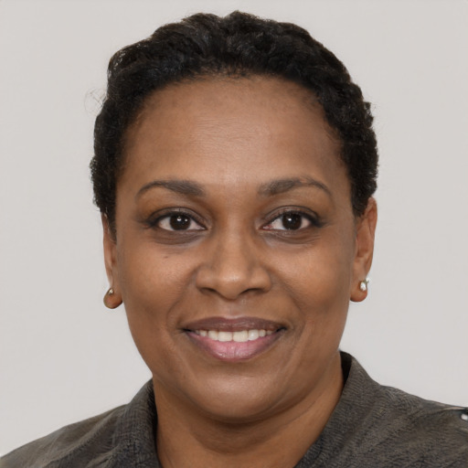 Joyful black adult female with short  black hair and brown eyes