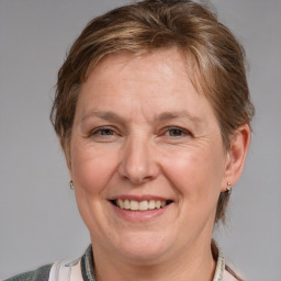 Joyful white adult female with medium  brown hair and blue eyes