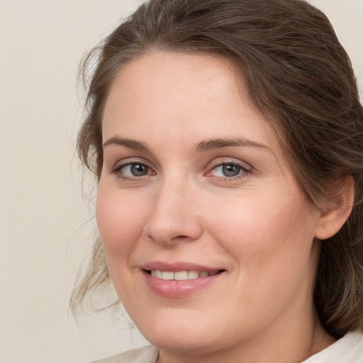 Joyful white young-adult female with medium  brown hair and green eyes