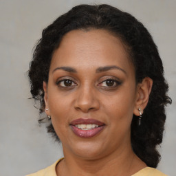 Joyful black adult female with medium  brown hair and brown eyes