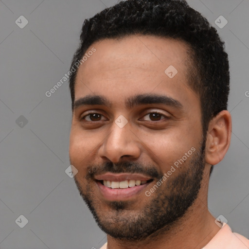 Joyful black young-adult male with short  black hair and brown eyes