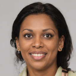 Joyful black adult female with medium  brown hair and brown eyes