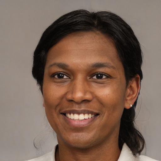 Joyful black adult female with medium  brown hair and brown eyes