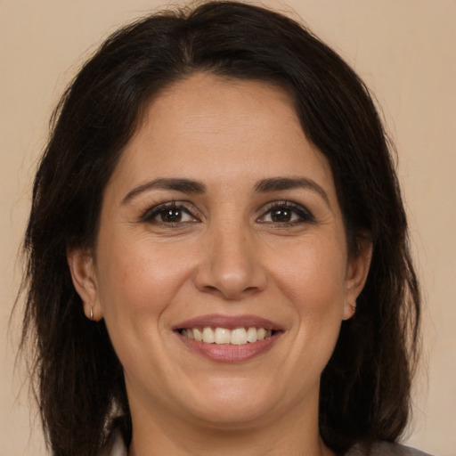 Joyful white adult female with medium  brown hair and brown eyes