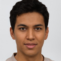 Joyful latino young-adult male with short  brown hair and brown eyes