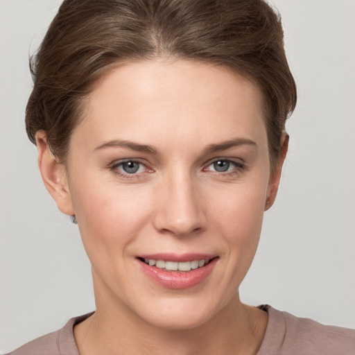 Joyful white young-adult female with short  brown hair and grey eyes