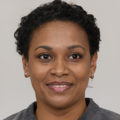 Joyful black adult female with short  black hair and brown eyes