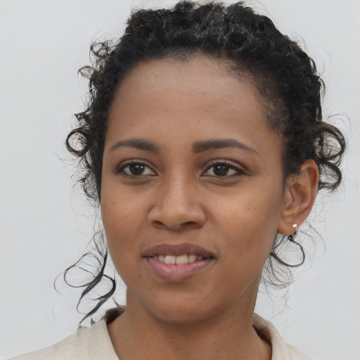 Joyful black young-adult female with short  black hair and brown eyes