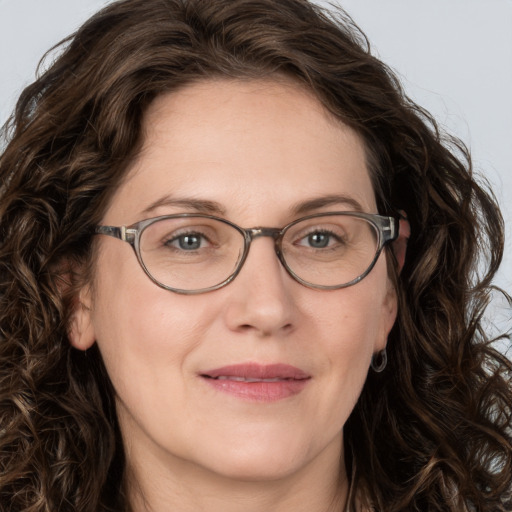 Joyful white adult female with long  brown hair and green eyes