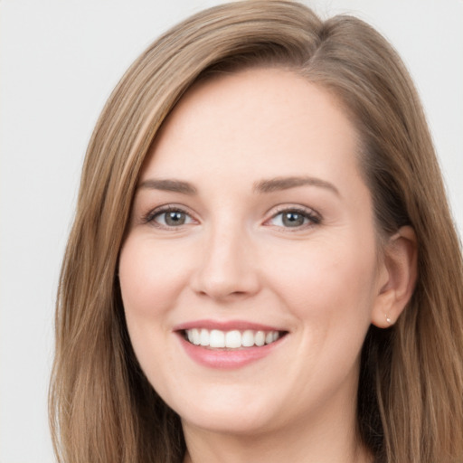 Joyful white young-adult female with long  brown hair and blue eyes