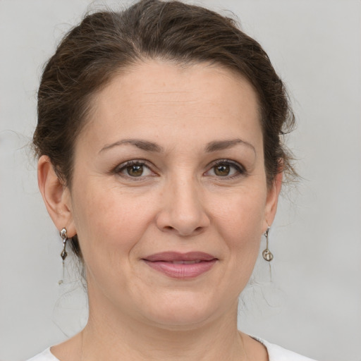 Joyful white adult female with medium  brown hair and grey eyes