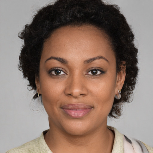 Joyful black young-adult female with short  brown hair and brown eyes