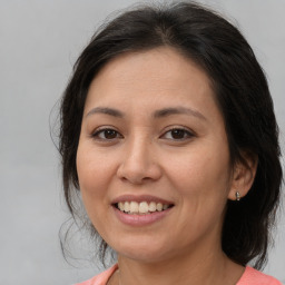 Joyful white adult female with medium  brown hair and brown eyes