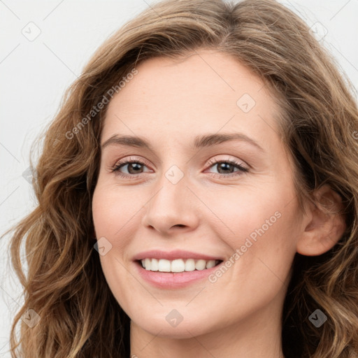 Joyful white young-adult female with long  brown hair and green eyes