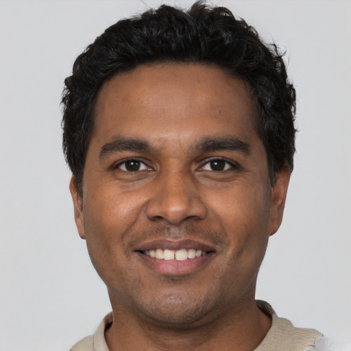 Joyful black young-adult male with short  black hair and brown eyes
