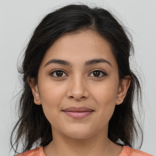 Joyful latino young-adult female with medium  brown hair and brown eyes