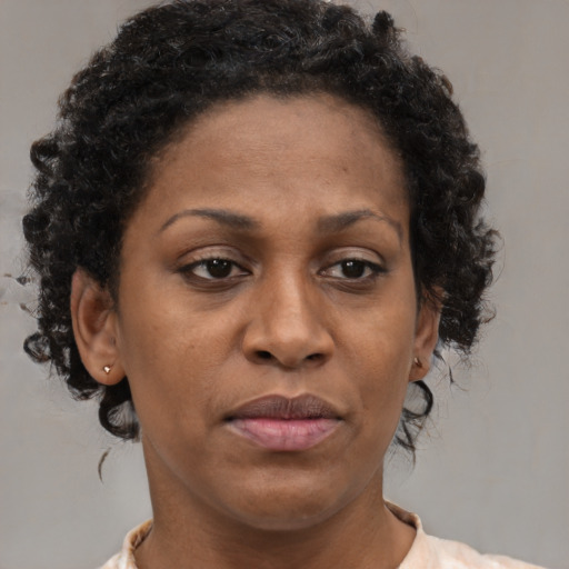 Joyful black adult female with medium  brown hair and brown eyes