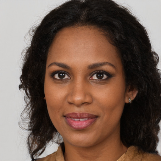 Joyful black young-adult female with long  brown hair and brown eyes