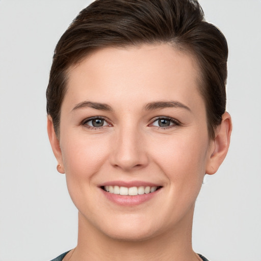 Joyful white young-adult female with short  brown hair and grey eyes