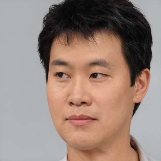 Joyful asian young-adult male with short  black hair and brown eyes