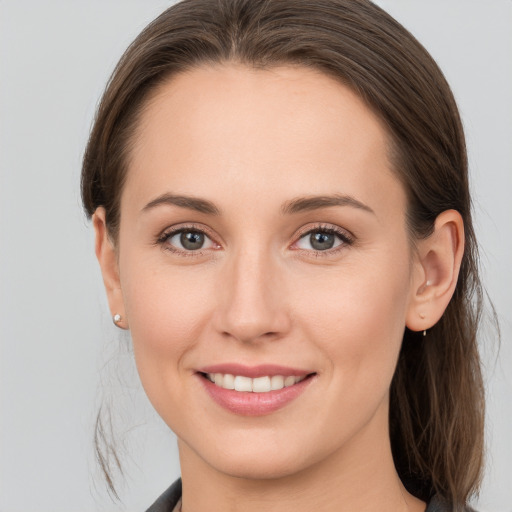 Joyful white young-adult female with long  brown hair and grey eyes